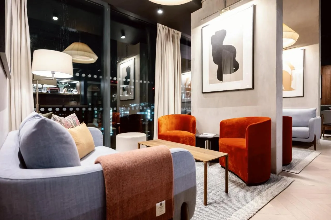 a lobby with couches and chairs and a table at Wilde Aparthotels Manchester City Centre in Manchester