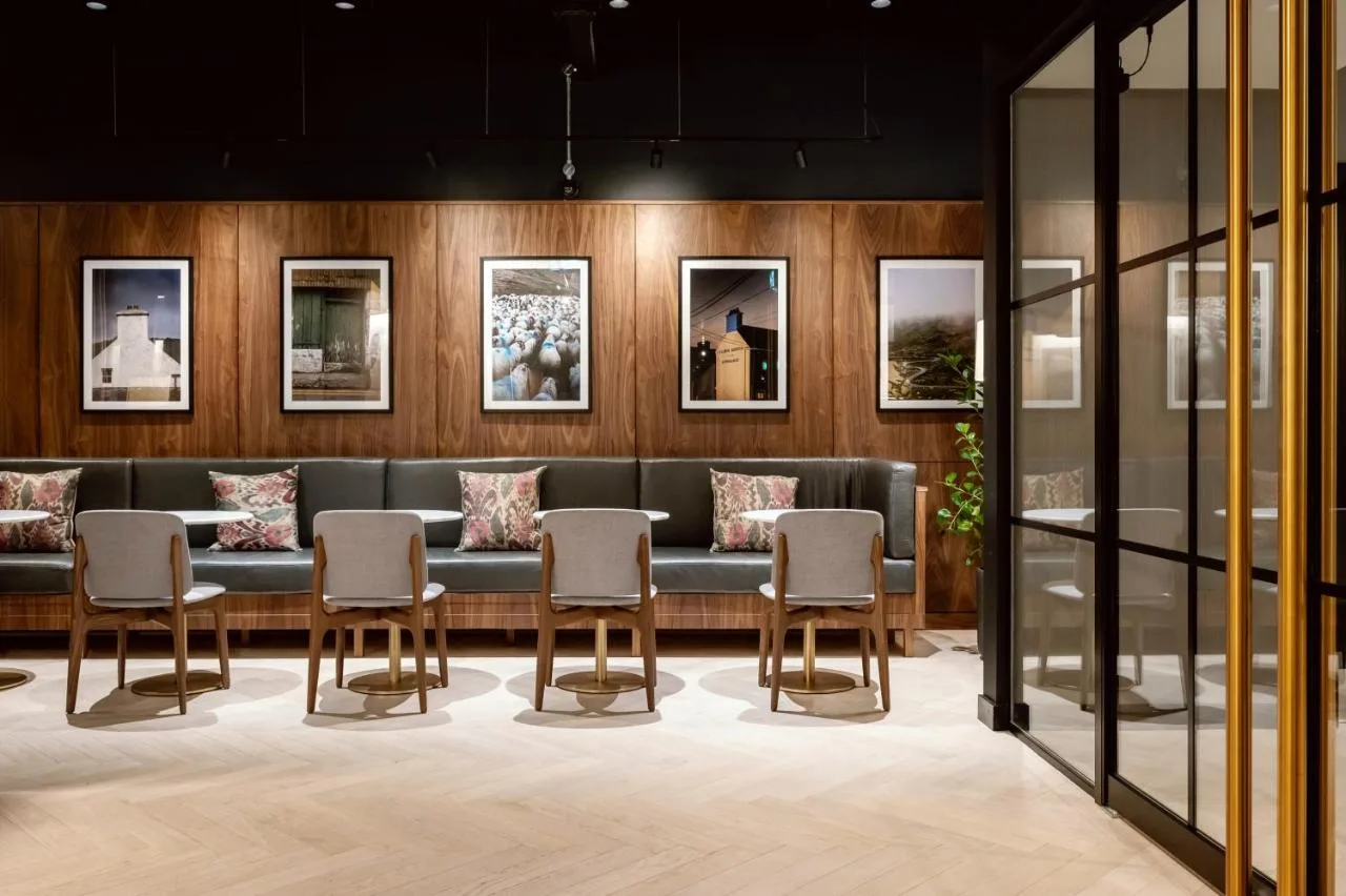 a waiting room with a couch and chairs at Wilde Aparthotels Manchester City Centre in Manchester