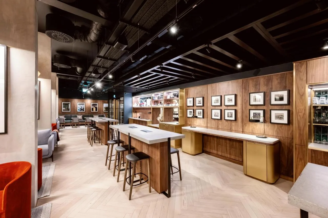 a bar with tables and stools in a restaurant at Wilde Aparthotels Manchester City Centre in Manchester