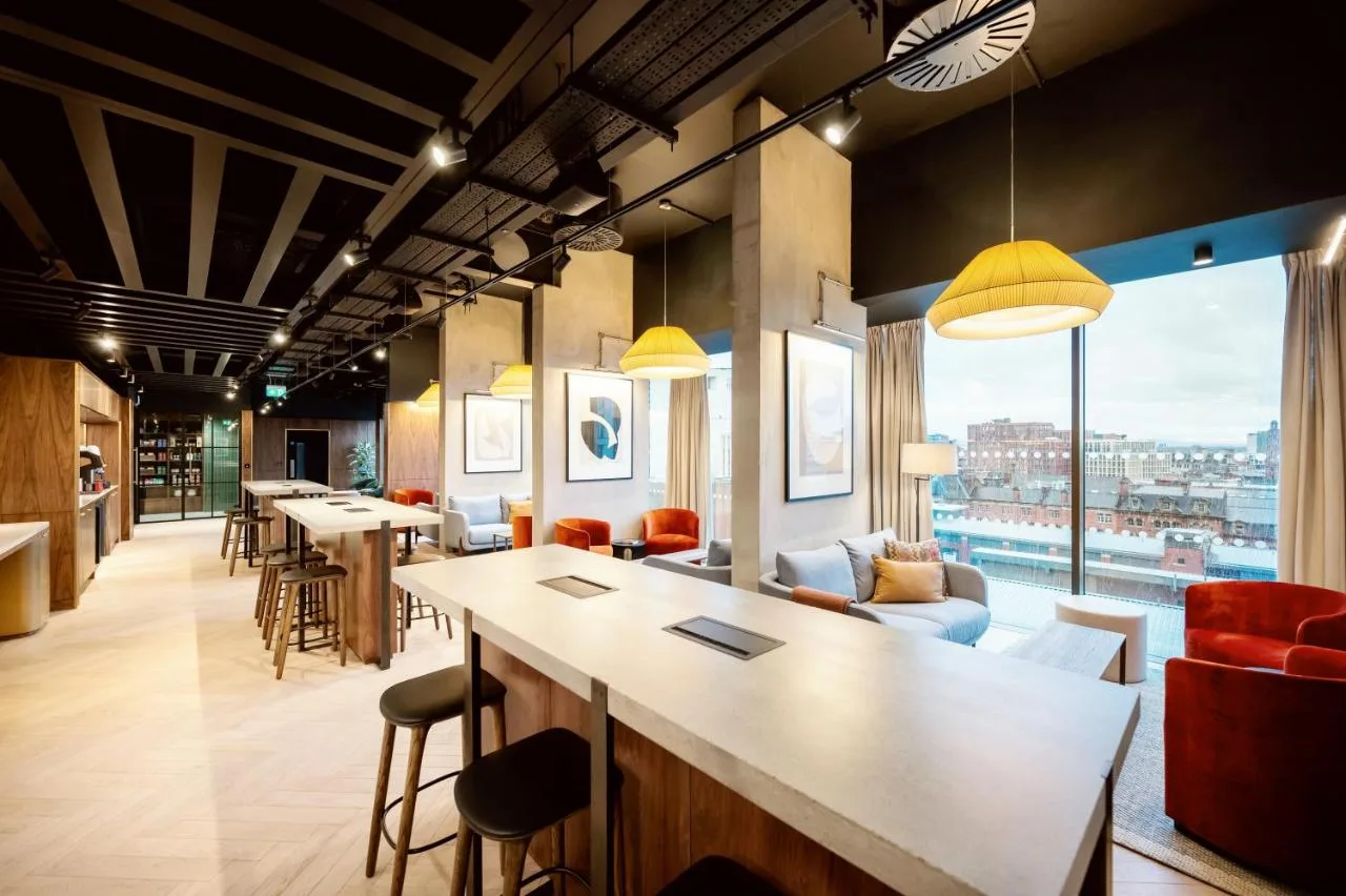 a lobby with a bar and tables and chairs at Wilde Aparthotels Manchester City Centre in Manchester